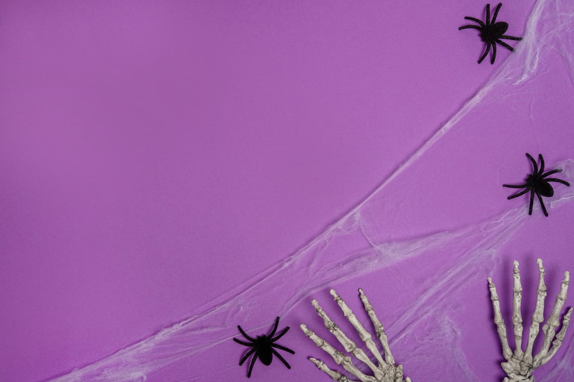 Halloween card with skeleton hands and spiders, purple background. Happy halloween banner mockup